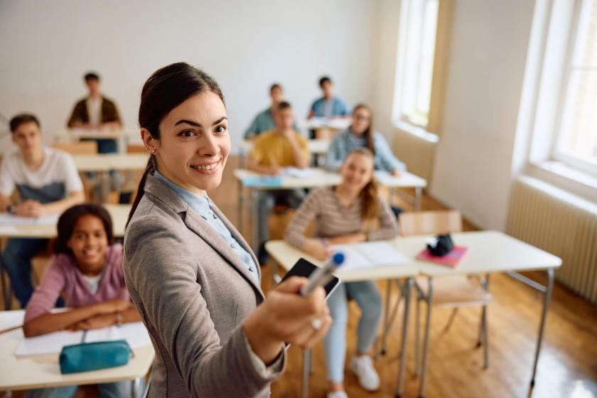 QA teacher points to the whiteboard.